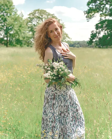 steph in meadow holding wild flowers